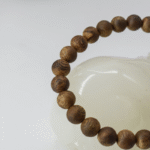 Close-up of 6mm Hainan Green Qinan agarwood beads with natural grain variation