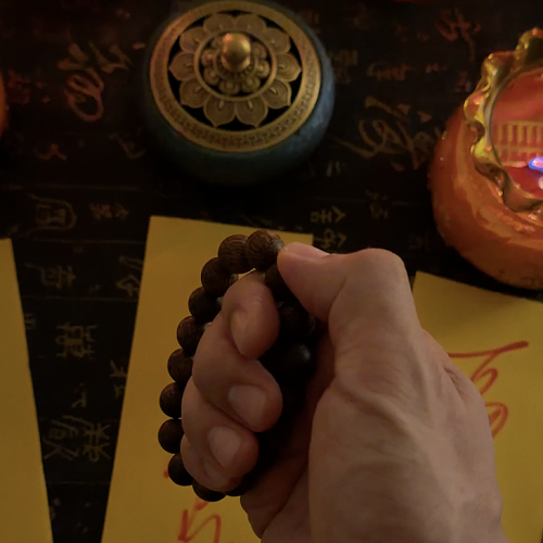 hand holding agarwood meditation beads bracelet